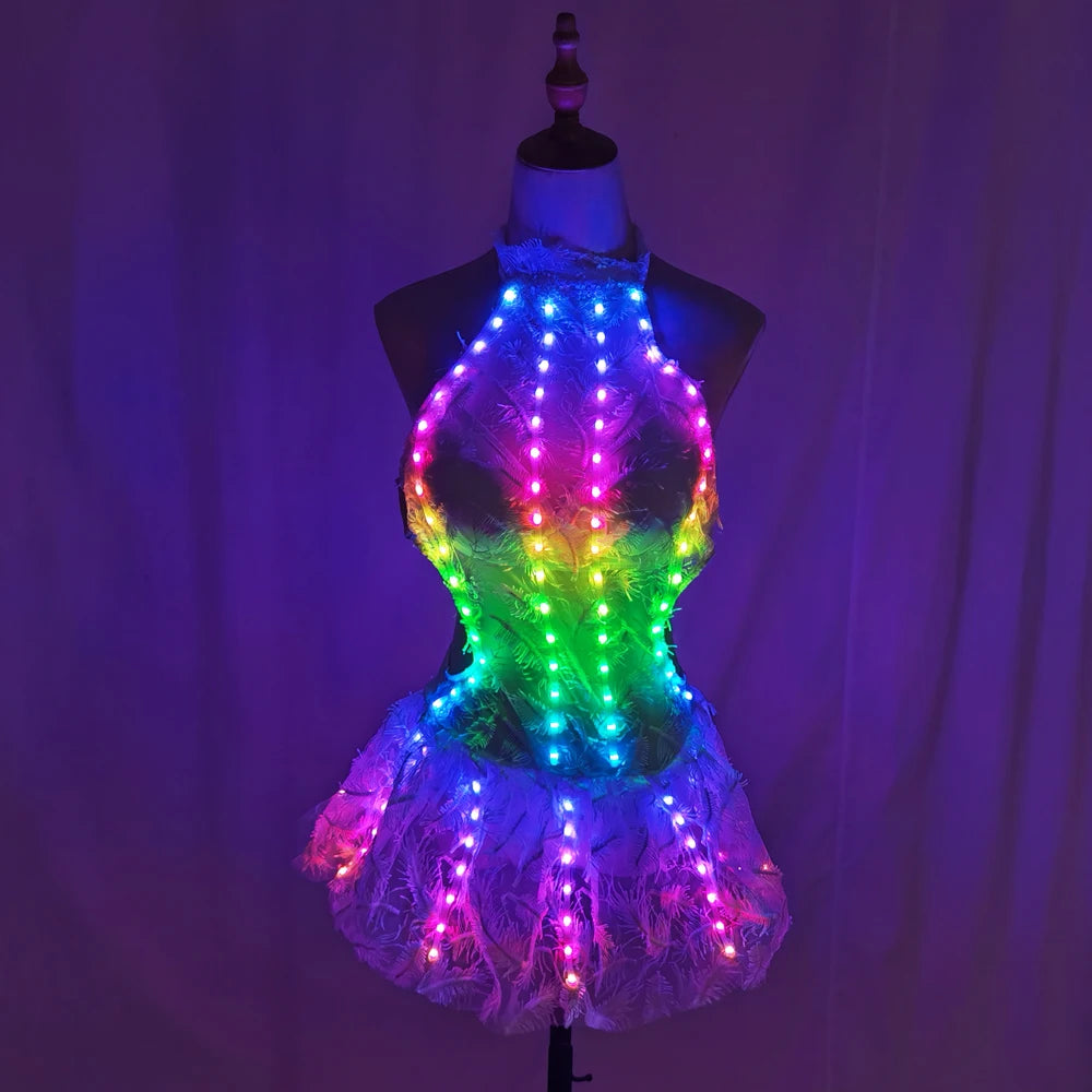 Halo LED Feather Mini Dress lit up in a dark room showing full rainbow LED effect